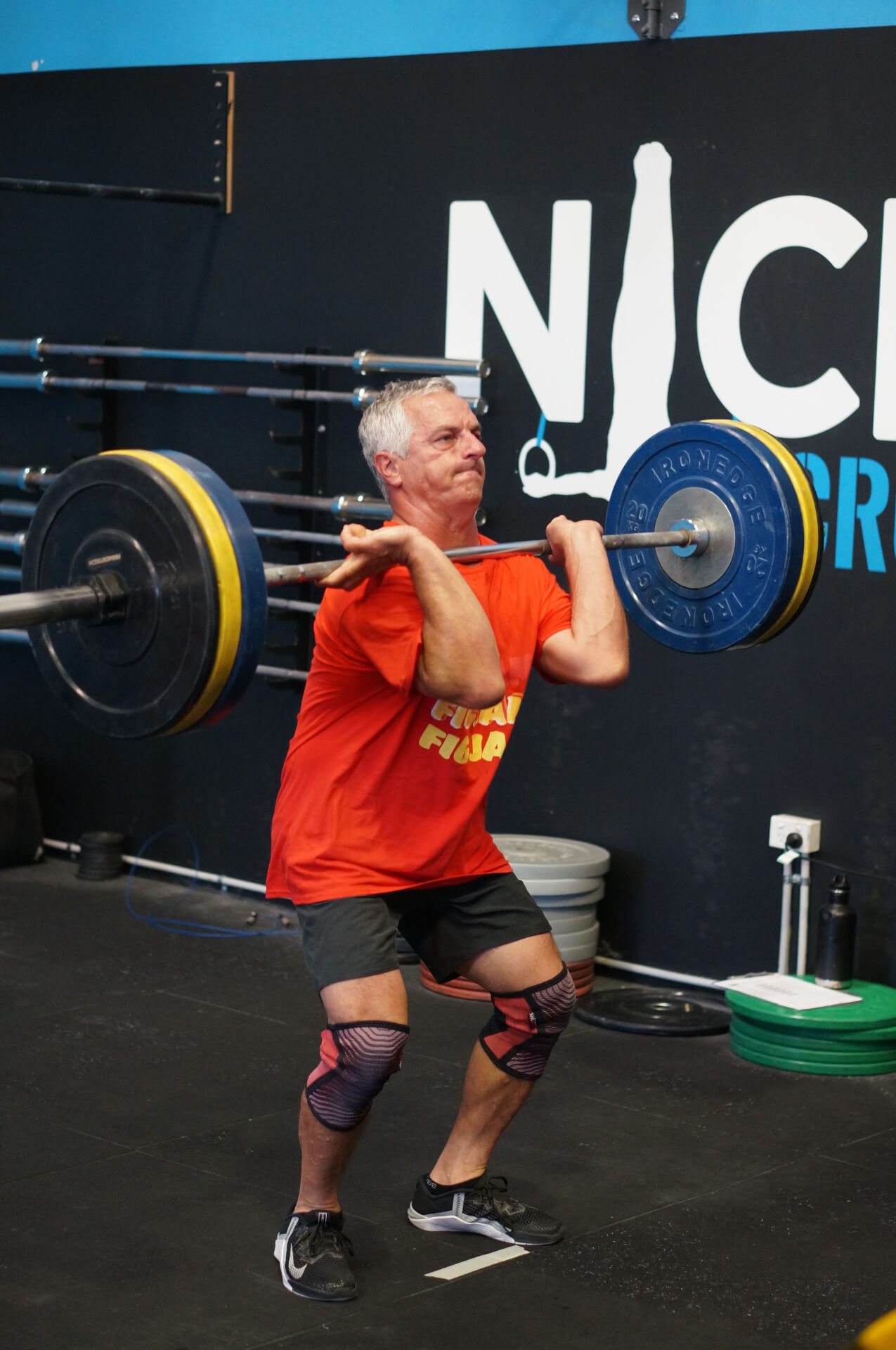 A member catching a barbell in the front rack