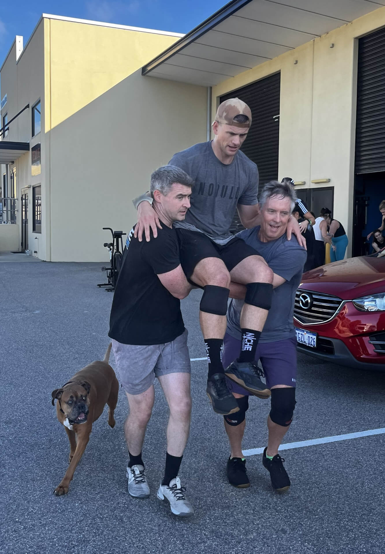Members carrying a mate outside the gym