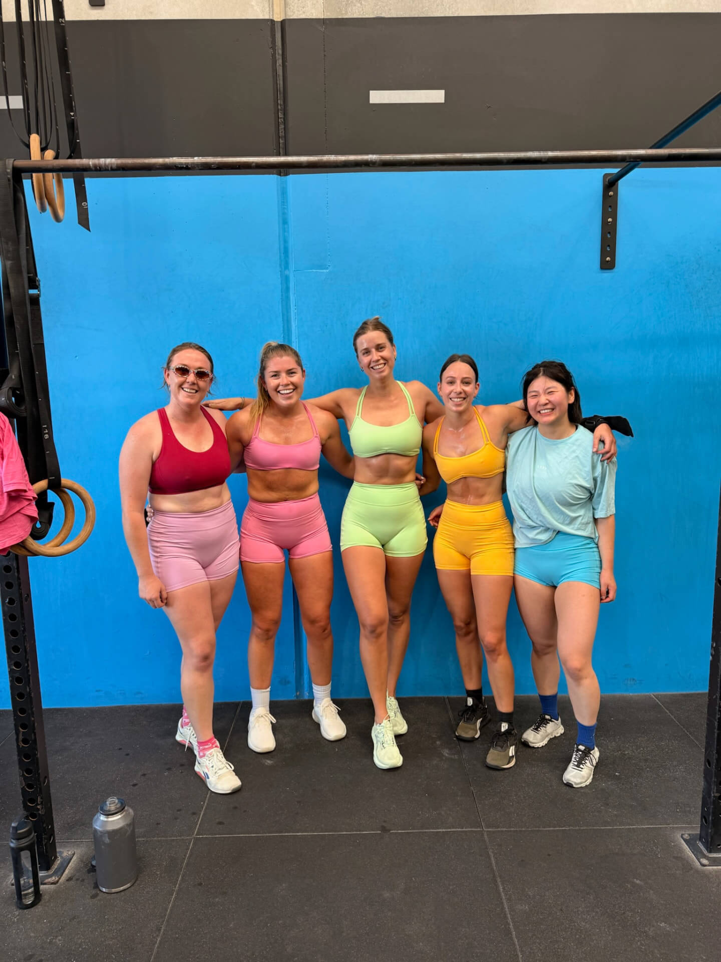 Members together in front of the blue wall at Niche CrossFit