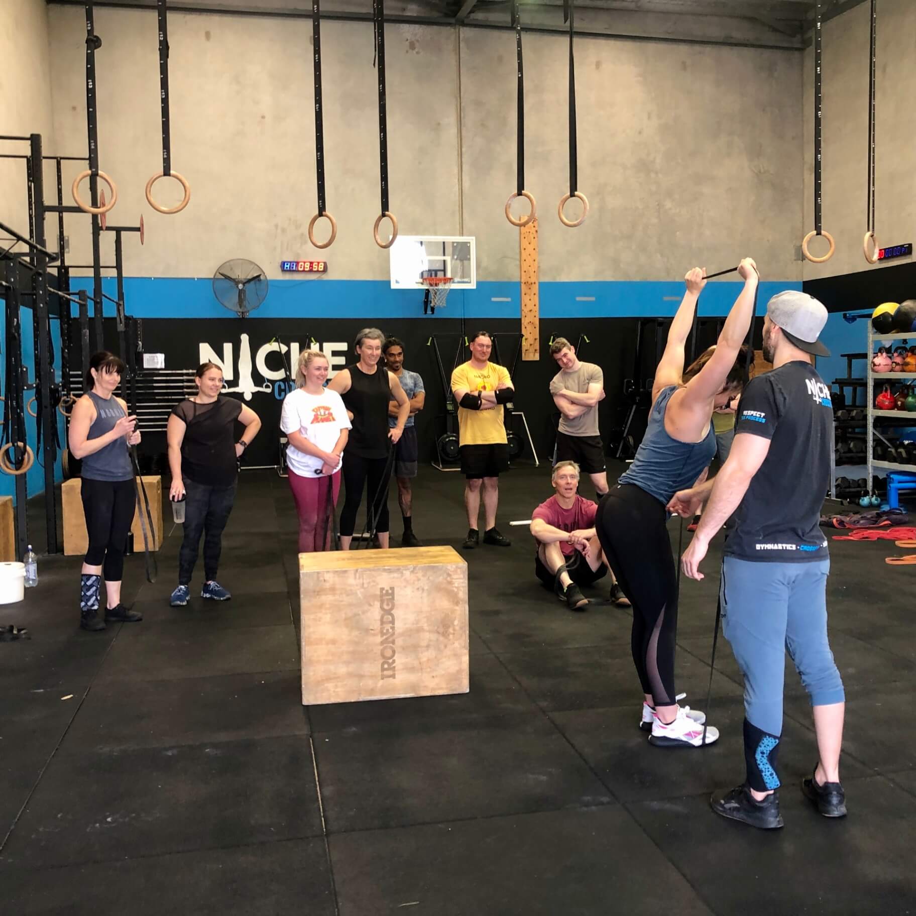 A coach demonstrating a movement to a class at Niche CrossFit