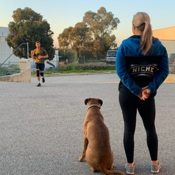 Stacey and the gym dog watching a member run outside Niche CrossFit